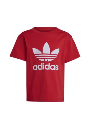 Czerwona koszulka bawełniana z dużym białym logiem Adidas i trzema równoległymi paskami poniżej logo. Krótkie rękawy i okrągły dekolt.