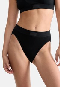 Zwarte katoenen slip met een brede tailleband, met een zachte textuur en delicate kantafwerking langs de randen. Minimale branding op de tailleband.