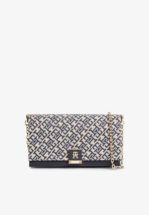 Sac bandoulière rectangulaire avec motif géométrique bleu et blanc, bandoulière chaîne dorée et fermeture noire avec détail logo doré.