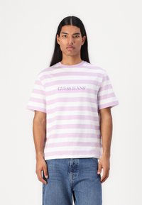Kortermet, rundhalset t-skjorte med vekslende lavendel- og hvite striper, med brodert "GUESS JEANS"-logo på brystet.