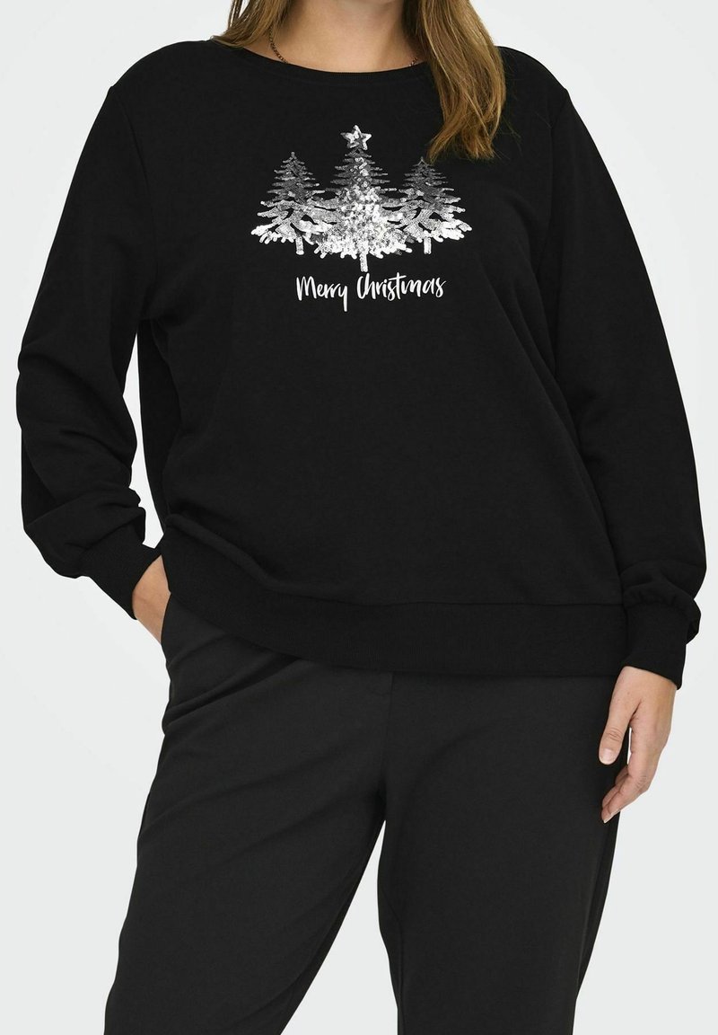 Sweat-shirt noir avec des sapins de Noël décorés de sequins argentés et une étoile, texte "Joyeux Noël", porté avec un pantalon noir assorti.