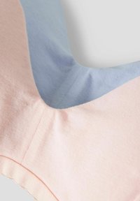 Top view of a garment featuring a pink and blue color-block design, made from soft fabric with a smooth texture and a scalloped edge detail.