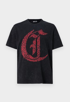 Musta puuvillapaita, jossa on etupuolella punainen leopardikuosisella "C":llä. Lyhyet hihat ja pyöreä pääntie, jossa on kulunut tekstuuri.