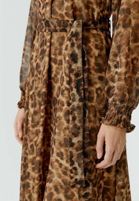 Leren jurk met luipaardprint van lichtgewicht stof, met een ceintuur in de taille, lange mouwen met gathered manchetten en een vloeiende silhouet.
