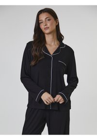Svart pyjamas set som inkluderar en knapp-up topp med vit piping, långa ärmar och fickdetalj, ihop med matchande byxor. Mjuk tyg.