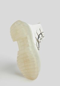 White ankle boot with a translucent thick sole, featuring silver hardware and hooks on the side. Smooth texture with a modern design.