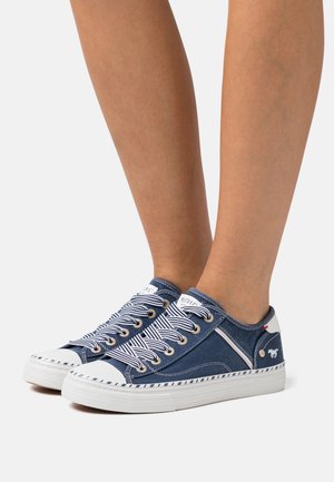 Blauwe canvas sneakers met witte rubberen zolen, gestreepte veters en decoratieve stiksels. Inclusief een logodetail nabij de hak.