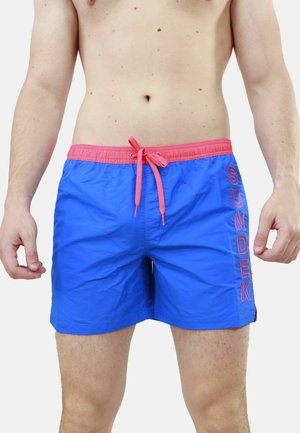 Pantaloni da nuoto blu con vita e cordino rosa. Presentano il logo 'SUNDEK' in rosa sul lato. Realizzati in un materiale leggero e morbido.
