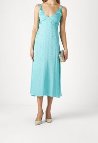 Valkoinen satiininen liukuva mekko V-päällä, ohutolkaimilla ja keskipitkällä helmalla. Yhdistettynä metalliseen clutch-laukkuun ja beigeisiin kärkitossuihin.