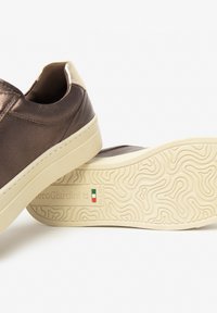 Braune Leder-Sneaker mit einer hellen Gummisohle, strukturiertem Muster und einem hinteren Lederelement. Die "NeroGiardini"-Markierung ist auf der Sohle sichtbar.