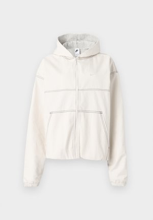 Hvid hættetrøje med lynlås lavet af blødt stof med hætte foret med gråt. Har sorte syninger, elastiske manchetter og et lille logo på brystet.