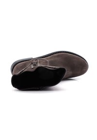 Ciemnobrązowy zamszowy botek za kostkę z bocznym zamkiem błyskawicznym i czarną podeszwą, pokazany leżący na boku na białym tle.