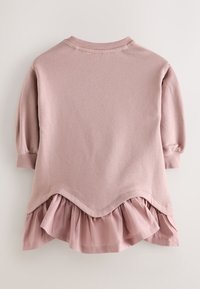 Vaaleanpunainen pitkähihaisen taaperoiden paita, jossa on resoriset hihansuut ja rypytetty helmareunus, joka ulottuu paidan kolmionmuotoisen leikkuureunan alapuolelle.