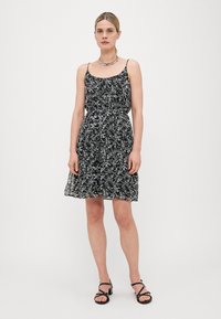 Vestido negro con estampado floral, tirantes finos, cintura fruncida y falda fluida; presenta patrones florales en blanco y azul claro.