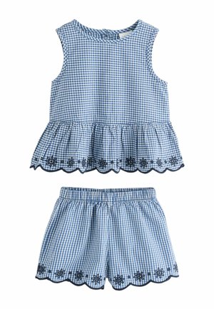 Bezrękawnik w niebiesko-białą kratkę z falbanką u dołu oraz dopasowane szorty z elastycznym pasem, oba z czarną kwiatową naszywką.