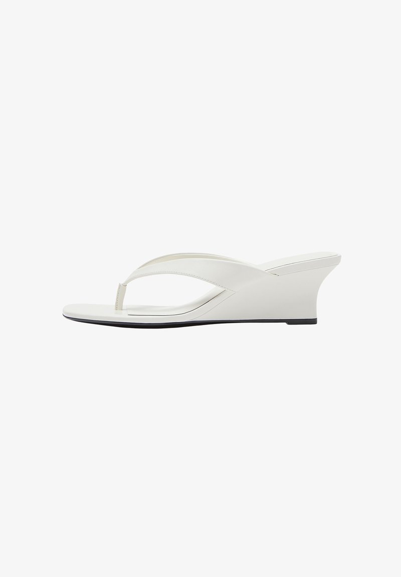 Sandale blanche à talon compensé avec des lanières lisses et une semelle légèrement surélevée, vue de côté sur fond blanc.