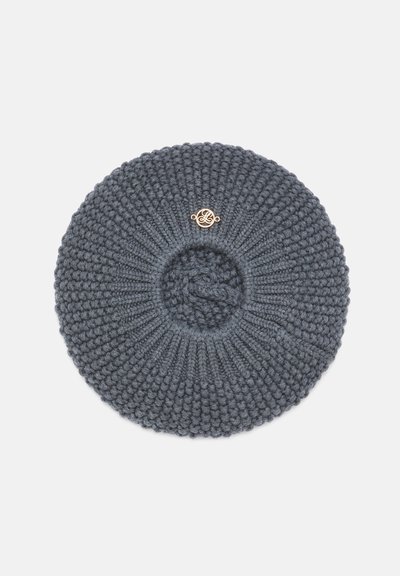 Béret rond tricoté gris foncé avec motif en côtes et boules, avec un petit emblème décoratif doré près du centre.