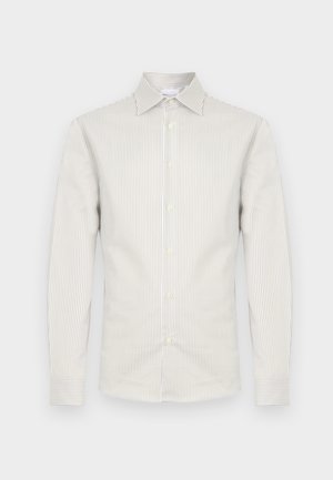Camisa de hombre de manga larga con estrechas rayas verticales beige y blancas, cierre frontal con botones, cuello puntiagudo y puños abotonados.