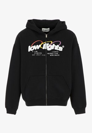 Czarna bluza z kapturem i zamkiem, z białym logo "low lights" i kolorowymi pętlami u góry, przednia kieszeń oraz tekst o produkcji i studiach.
