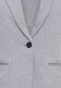 Veste grise à motif avec un revers cranté, une fermeture à un bouton et des poches latérales, finition en tissu texturé.