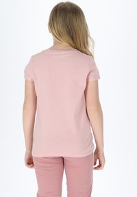 Light pink cotton t-shirt with short sleeves, crew neck, and a relaxed fit, paired with matching light pink pants, viewed from the back.