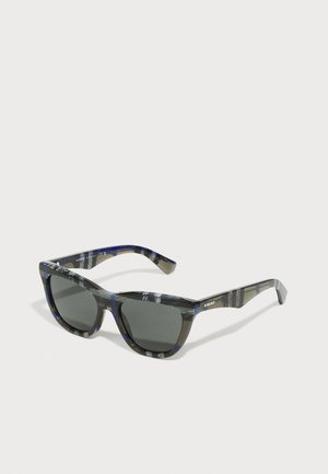 Gafas de sol con un patrón en negro y gris, acabados en brillo, con lentes gris oscuro y montura angular con acentos azules.