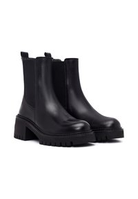Bottines en cuir noir à panneaux élastiques sur les côtés, bout arrondi et talon épais. Semelle texturée avec de profonds rainures pour une adhérence optimale.