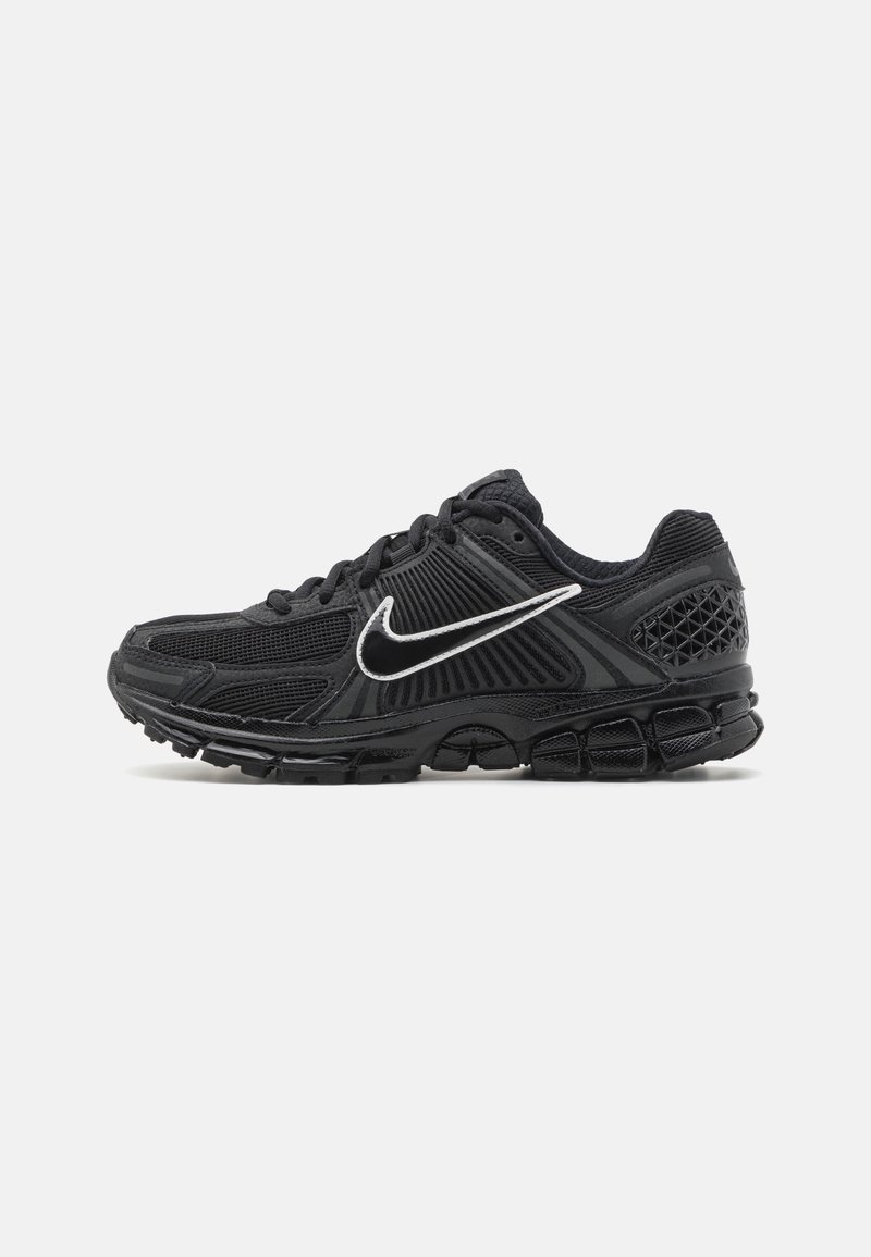 Černá běžecká obuv Nike s bílým logem swoosh, texturovaná síťovina na svršku a segmentovaná polstrovaná podrážka na bílém pozadí.