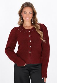 Cardigan bordeaux con maniche a sbuffo, chiusura a bottoni e strass decorativi sul colletto. Tessuto morbido con polsini a coste.