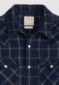 Marine geruit overhemd van corduroy, met witte lijnen, twee borstzakken en witte drukknoopsluitingen. Label toont Levi Strauss branding.