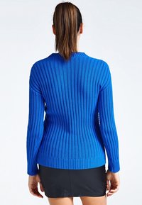 Sininen resorineulepusero, jossa on pyöreä pääntie ja pitkät hihat. Valmistettu pehmeästä neuloksesta, istuvalla siluetilla ja teksturoidulla kuviolla.