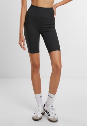 Bermudas ciclistas negras de tiro alto en una tela elástica. Textura suave con un diseño ajustado, que llega justo por encima de la rodilla.