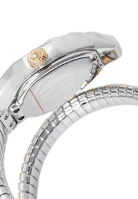 Srebrnoblago ročno uro z teksturirano ohišjem, zlatim kronom in prilagodljivim kovinskim zapestjem, ki vsebuje povezave. Vgraviran logotip na hrbtni strani.