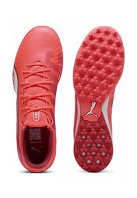 Bottines de football, d'un rouge corail vif avec une finition texturée, design à lacets, et une semelle à motif hexagonal pour une meilleure traction. Logo Puma affiché.