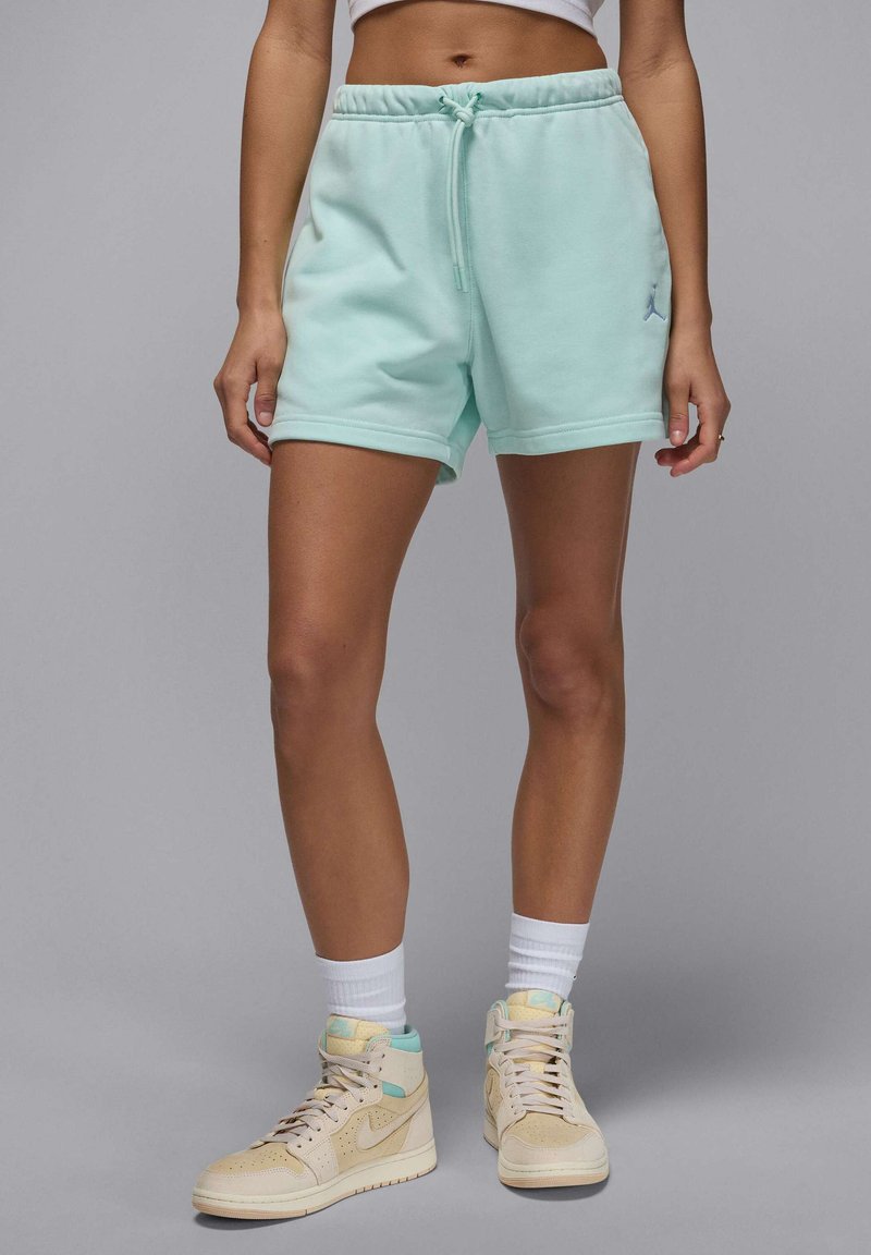 Mintgrön sweatshirtshorts med elastiskt midjeband och dragsko. Matchas med beige högskoor och vita ankelsockor.