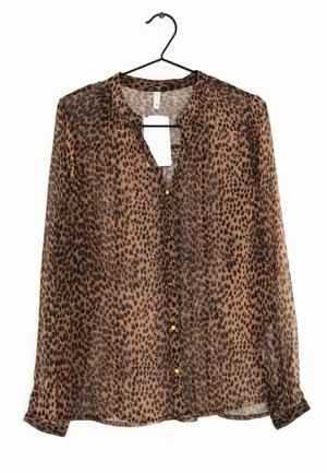 Blusa transparente de estampado animal marrón con botones delanteros, mangas largas y escote redondo. Presenta pequeños botones dorados y una textura ligera.