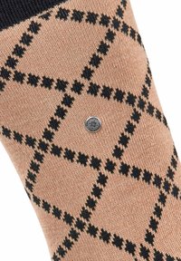 Calzino beige con un motivo a scacchi neri, caratterizzato da una superficie in maglia testurizzata e un piccolo etichetta con logo argento sul lato.