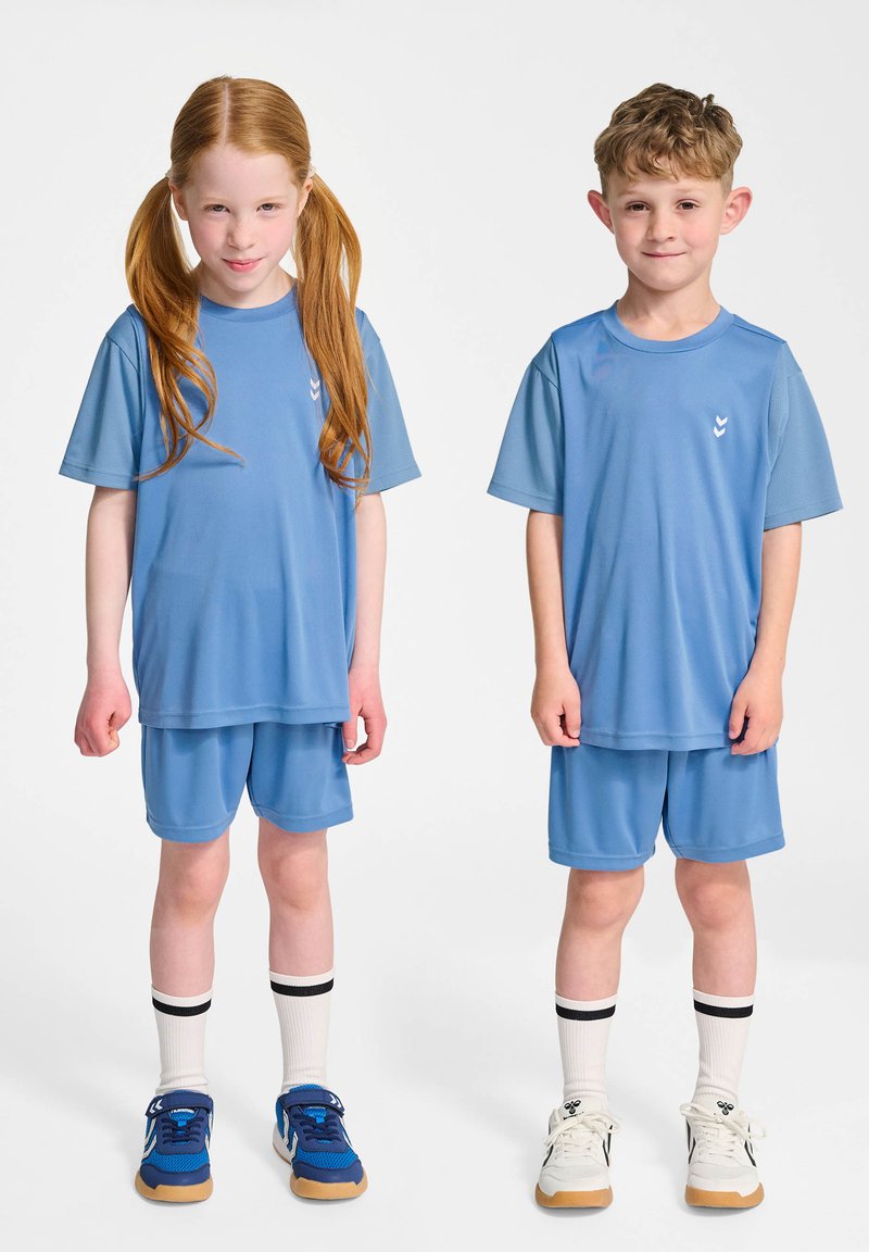 Deux enfants portent des tenues sportives assorties de couleur bleu clair, comprenant des t-shirts à manches courtes et des shorts, avec des détails de logo blancs contrastés.