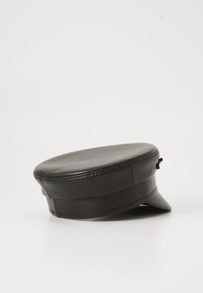 Must musta topi mustast nahast, millel on lühike jäik visor ja dekoratiivne külgriba, esitatud ühetaolise valge tausta ees.