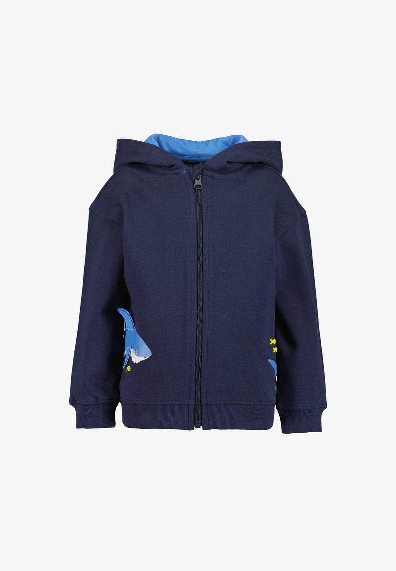 Haut à zip marine en mélange de coton, avec une doublure bleue, un design de requin et des accents jaunes sur les poches. Texture douce et coupe décontractée.