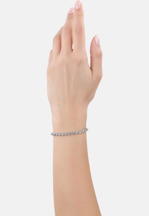 Pulsera de cadena de metal plateado llevada en una mano, que presenta un diseño retorcido y una textura lisa y pulida.
