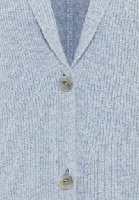 Hellblau gestrickte Strickjacke mit V-Ausschnitt, die einen kleinen grauen Knopf vorne hat. Die Textur ist weich und gerippt.