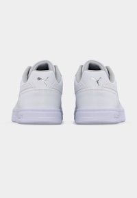 Λευκά δερμάτινα αθλητικά παπούτσια με ομαλή υφή, στρογγυλεμένο σχήμα και διακριτικές γκρι λεπτομέρειες. Φέρουν λογότυπο στη φτέρνα και λάστιχο σόλας.