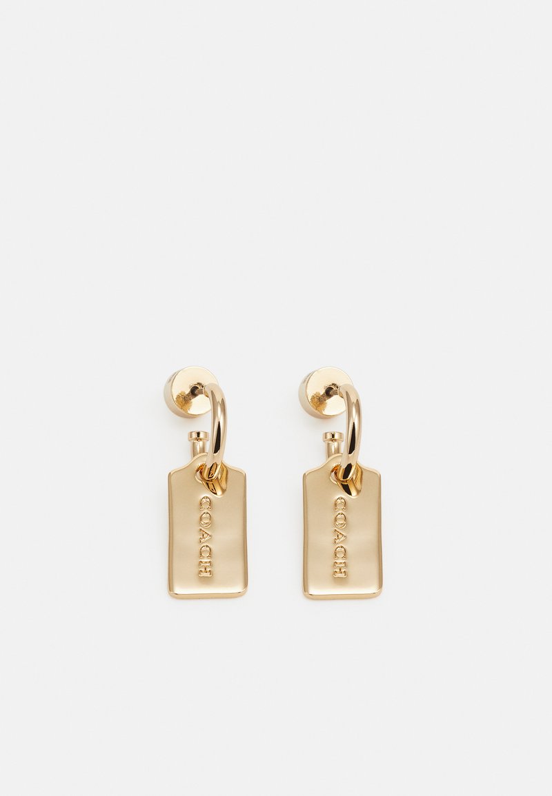 Boucles d'oreilles en métal doré avec des pendentifs rectangulaires, chacun arborant le logo 'COACH' en relief. Surface lisse et polie ; design minimaliste.