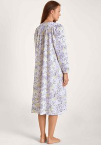 Blumennachtkleid mit langen Ärmeln, gerafftem Rückenteil und einem helllila Grundton mit gelben und lavendelfarbenen Akzenten. Weicher Stoff mit lockerer Passform.