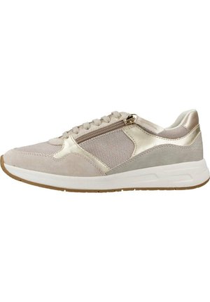 Zapatilla deportiva beige con parte superior de malla, acentos de ante, detalles metálicos y un zipper lateral. Cuenta con una entresuela blanca y suela de goma.