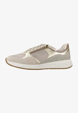 Zapatilla deportiva beige con parte superior de malla, acentos de ante, detalles metálicos y un zipper lateral. Cuenta con una entresuela blanca y suela de goma.