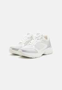 White sneakers with silver accents, made of mesh and synthetic material. Features a rounded toe, lace-up design, and cushioned sole.