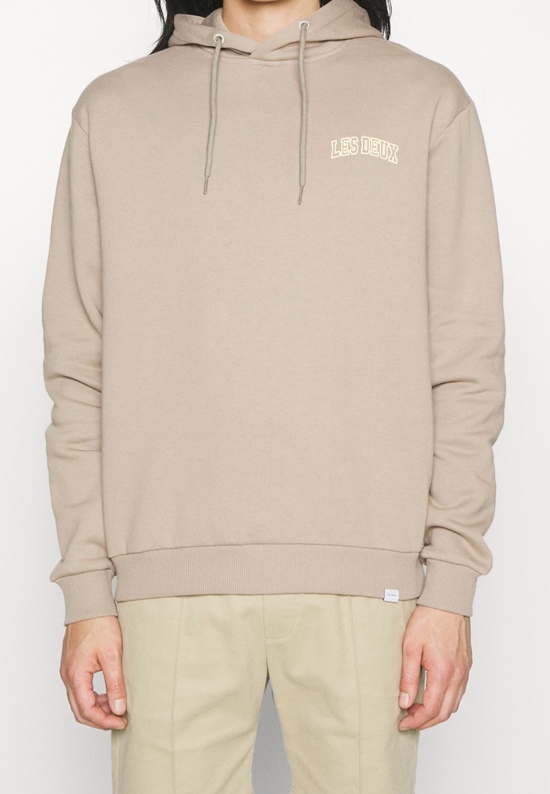 Felpa beige con tasca frontale a marsupio, coulisse regolabile e un piccolo logo "LES DEUX" ricamato in contrasto di colore crema.