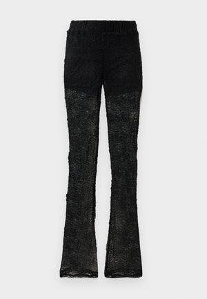 Pantalons évasés en dentelle noire avec une taille élastique. Le matériau présente un motif texturé, avec une section inférieure semi-transparente.
